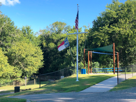 View of the picnic shelter and American flag at greenway entrance