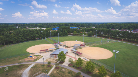Drone footage of the multi-purpose ball fields with trails in the background