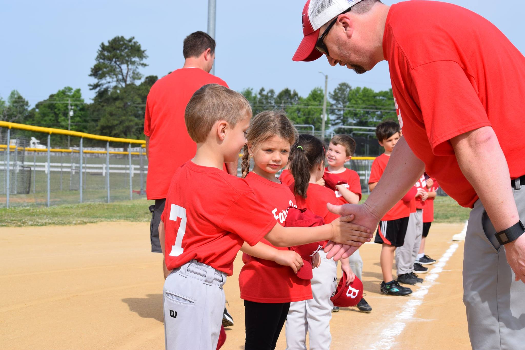 t-ball coach congratulating young players