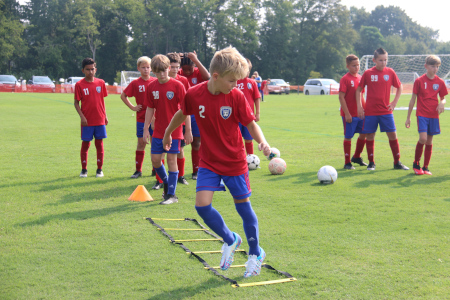 Young soccer player performing some drills on the practice field
