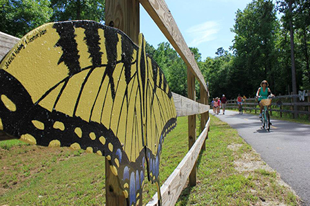 Wood carving of a butterfly, located at the greenway's picnic area by the creek