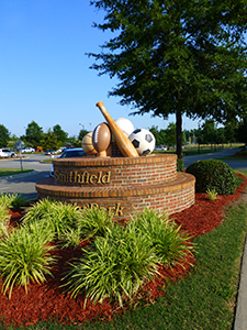Main entrance sign that has sports equipment on top