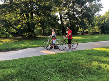 Family on bikes enjoying the greenway/riverwalk