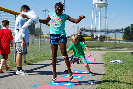 Kids playing hopscotch along the loop track