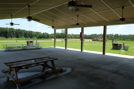 View of picnic shelter, displaying grills, ceiling fans, and tables